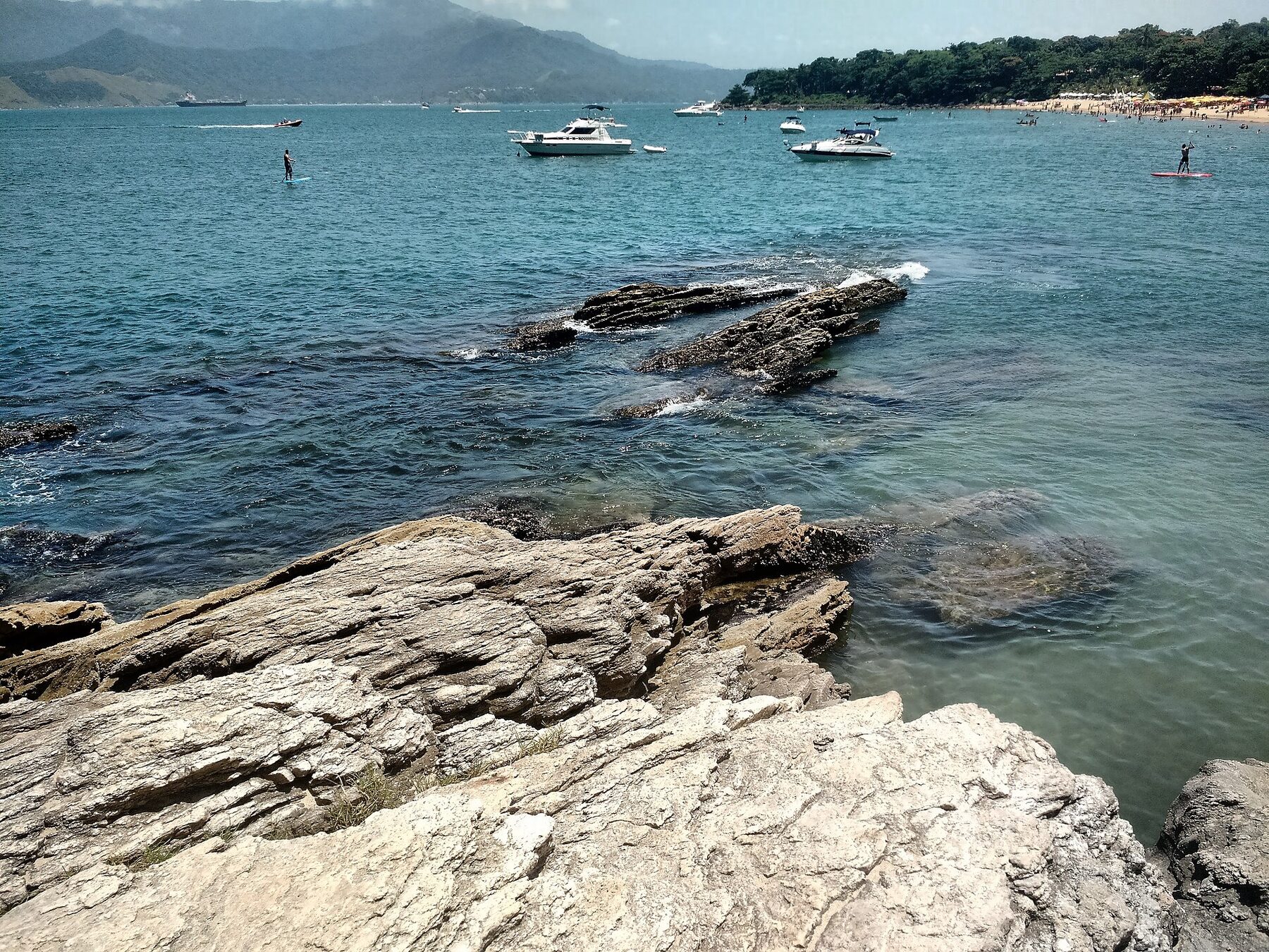 Mar, pedras e embarcações próximos à Praia do Curral